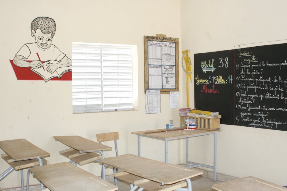 A well-lit classroom with wooden desks, chalkboard, and educational decor, creating a learning environment
